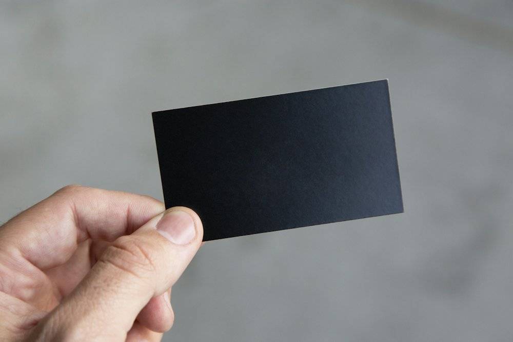 Hand holding a black business card